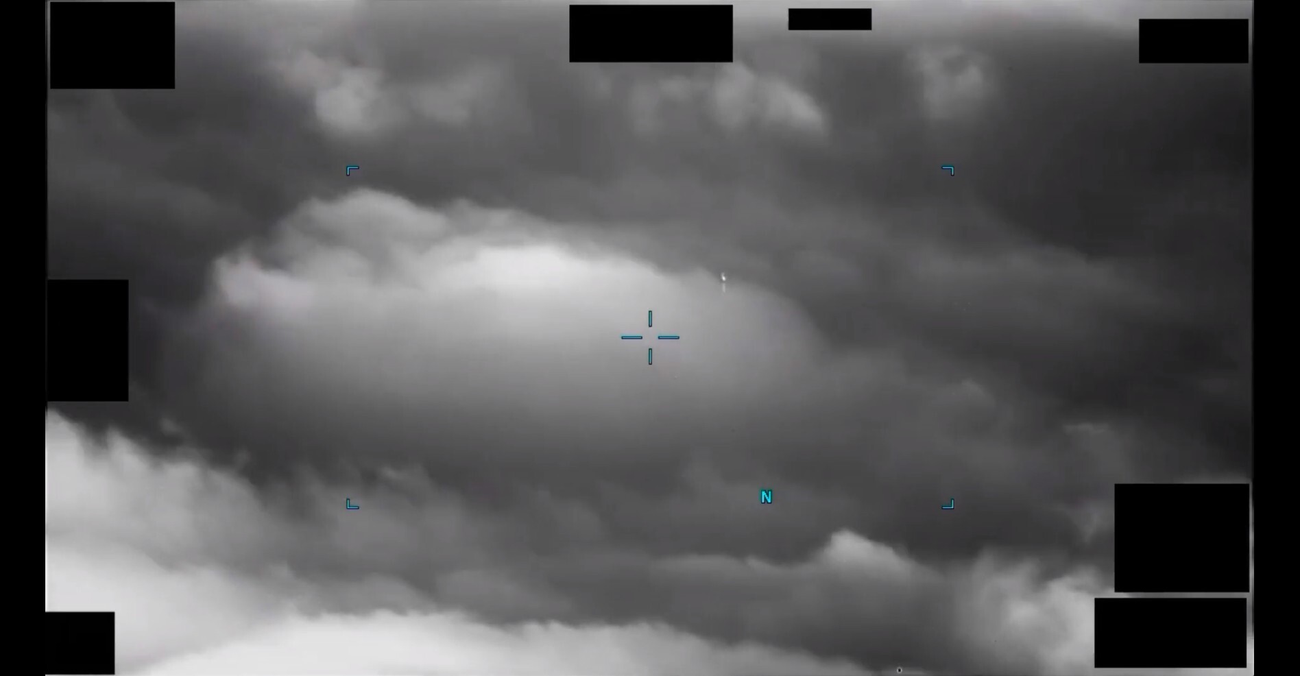 A still image extracted from an infrared video depicting an area of contrast superimposed against clouds.