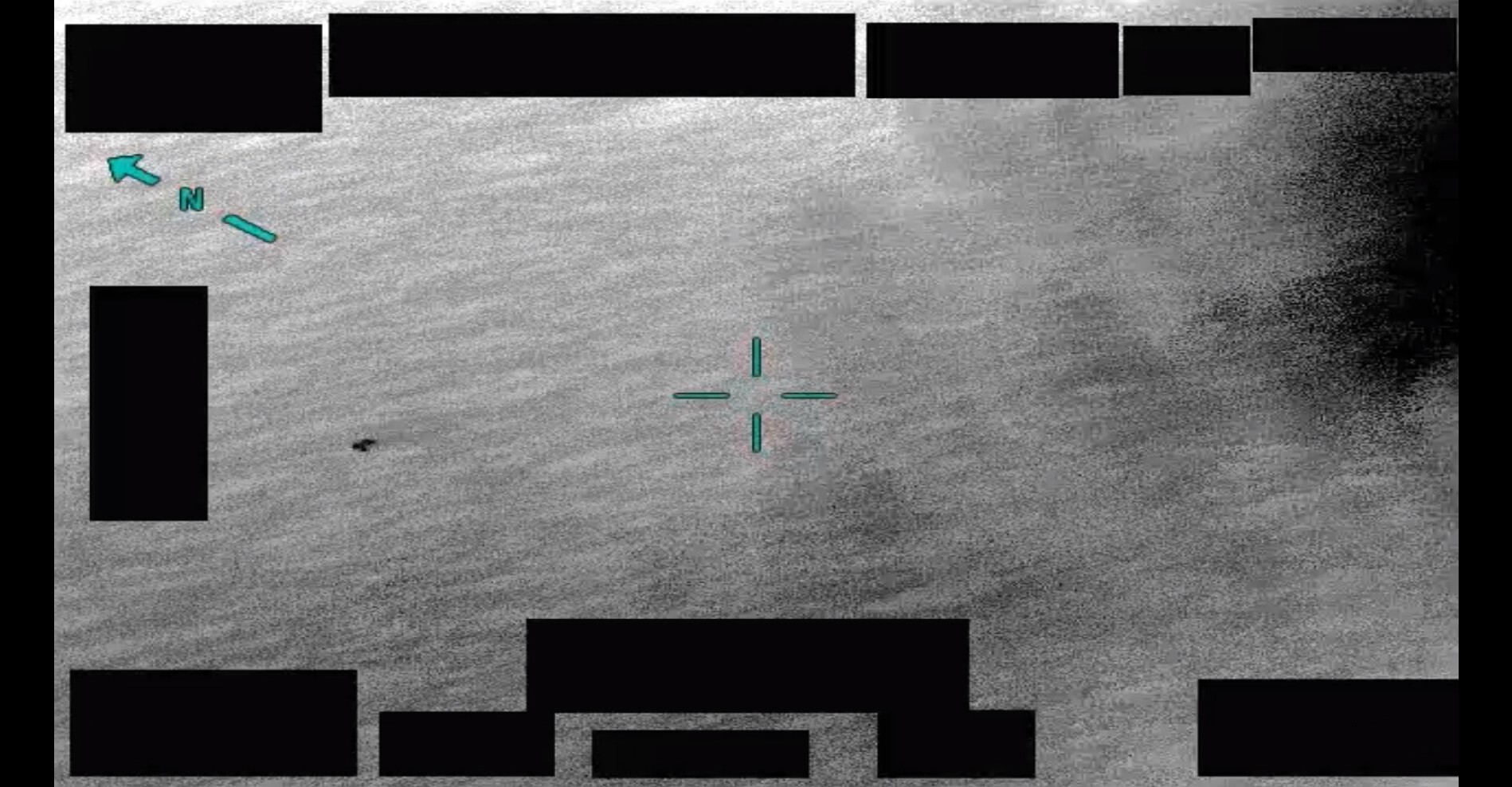 A still image extracted from an infrared video depicting an area of contrast superimposed against the surface of a body of water.