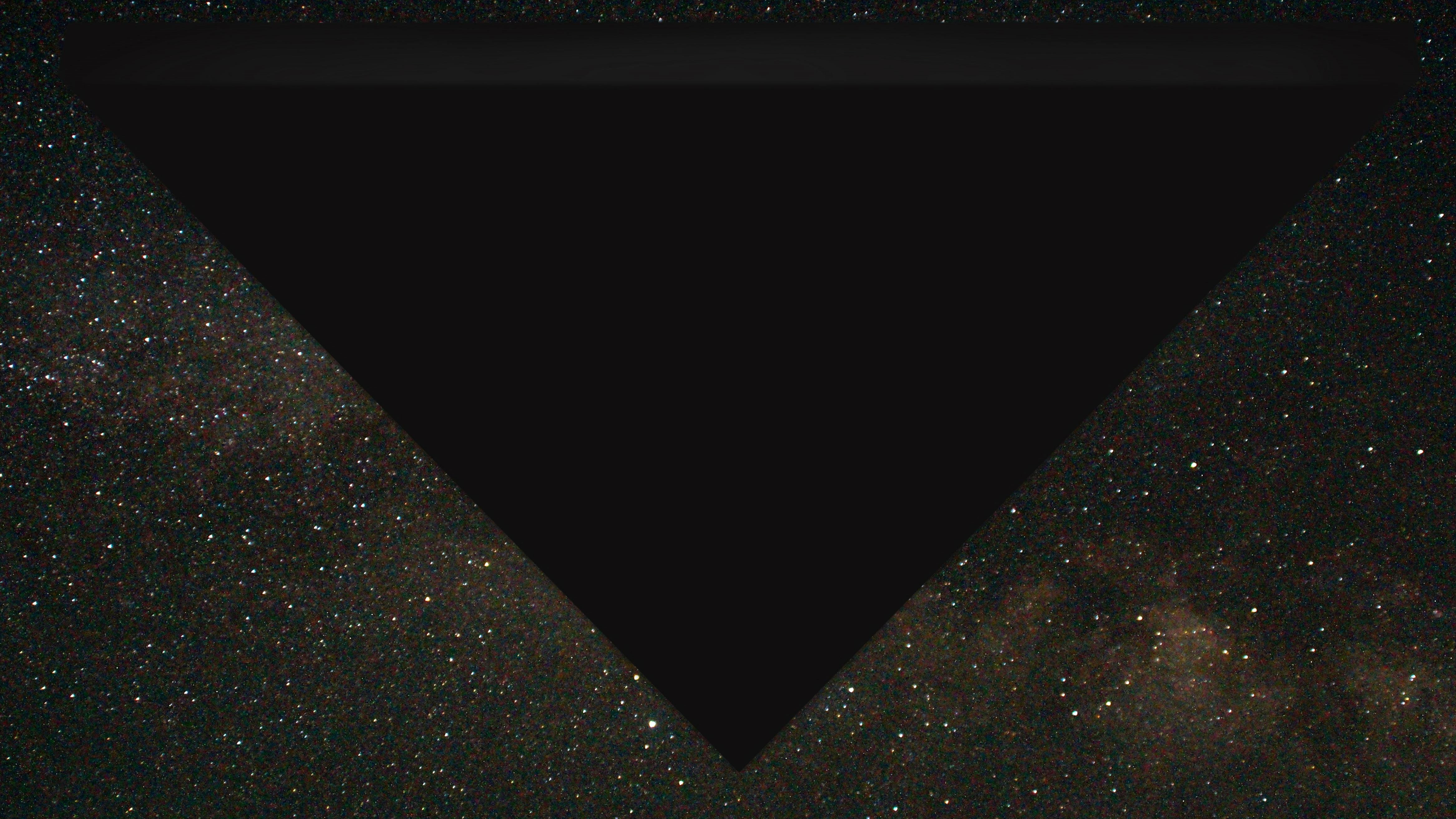 A digital rendering of a large, dark triangle against a starry night sky.