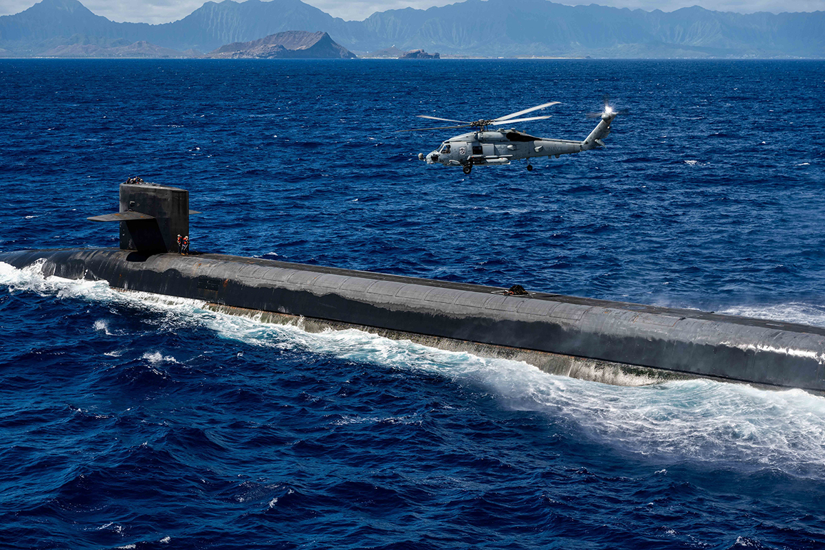 An MH-60R Sea Hawk hovering over the Ohio-class ballistic-missile submarine USS Henry M. Jackson.